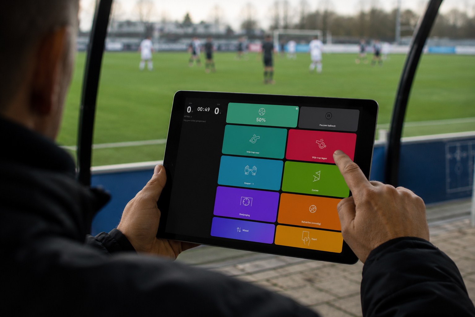 Coach registreert een actie op de tablet vanuit de dugout